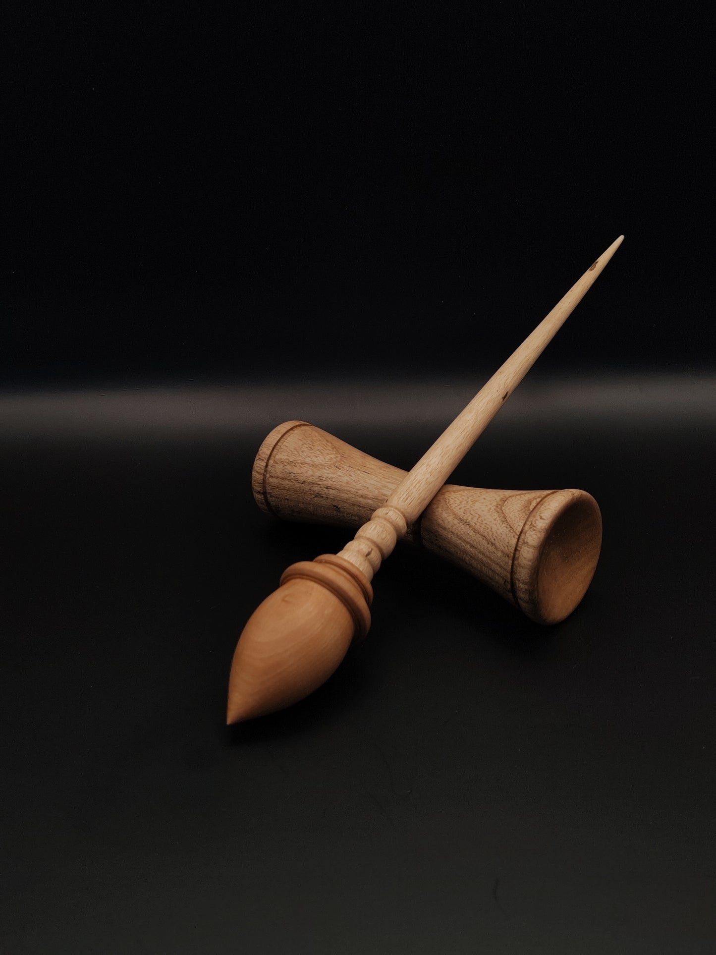 Elegant wooden support spindle with a sycamore shaft and plum wood whorl, accompanied by a matching pear wood support bowl. The design emphasizes craftsmanship and the natural beauty of the wood.