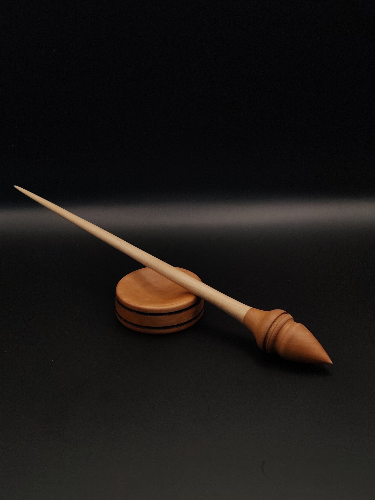 Handcrafted wooden support spindle with a sycamore shaft and plum wood whorl, paired with a smooth round pear wood support bowl. The spindle set showcases elegant craftsmanship and a natural wood finish