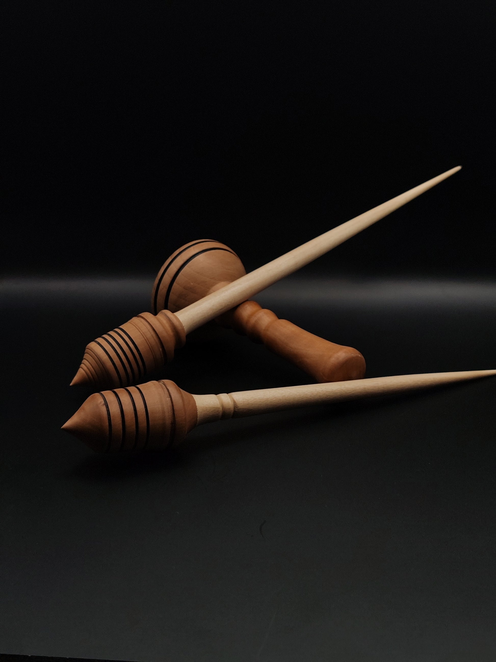 support spindle with a sycamore shaft and plum wood whorl, accompanied by a matching pear wood support bowl. The design emphasizes craftsmanship and the natural beauty of the wood.