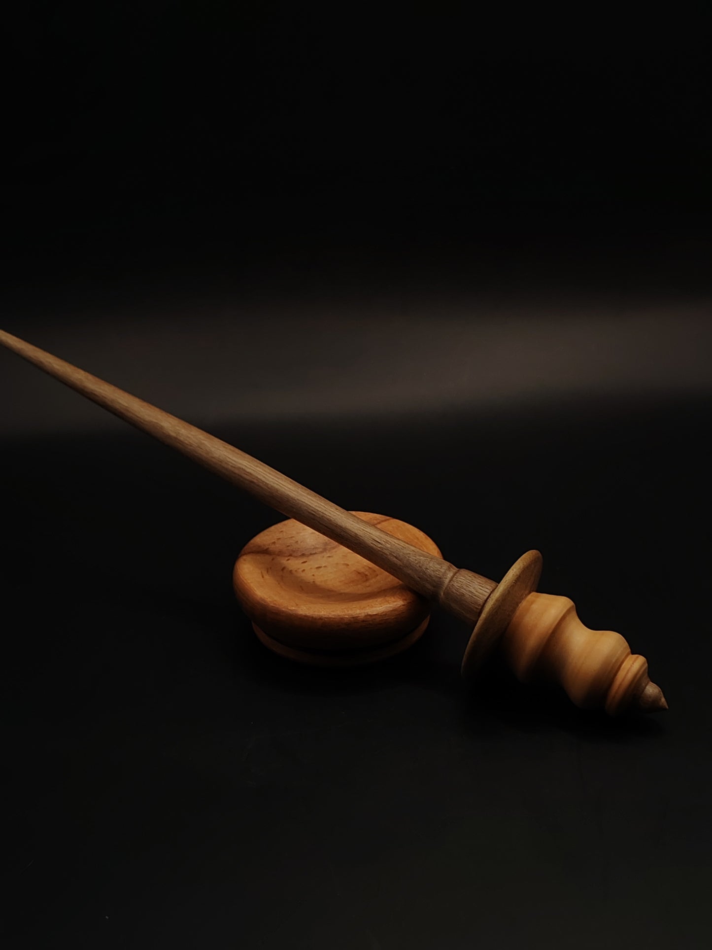 A lightweight 20 g artisan support spindle featuring a pear wood whorl, walnut shaft, and a beech support bowl — smooth, elegant, and perfect for fine to medium spinning.