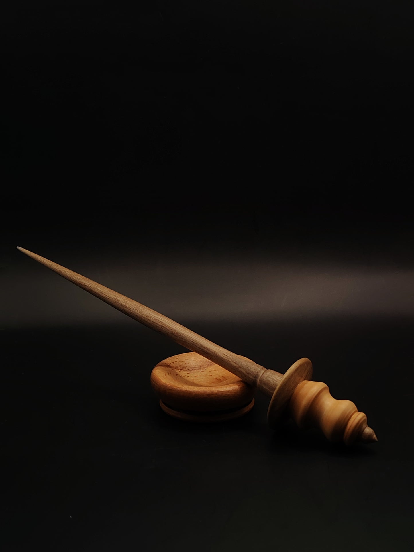 A lightweight 20 g artisan support spindle featuring a pear wood whorl, walnut shaft, and a beech support bowl — smooth, elegant, and perfect for fine to medium spinning.