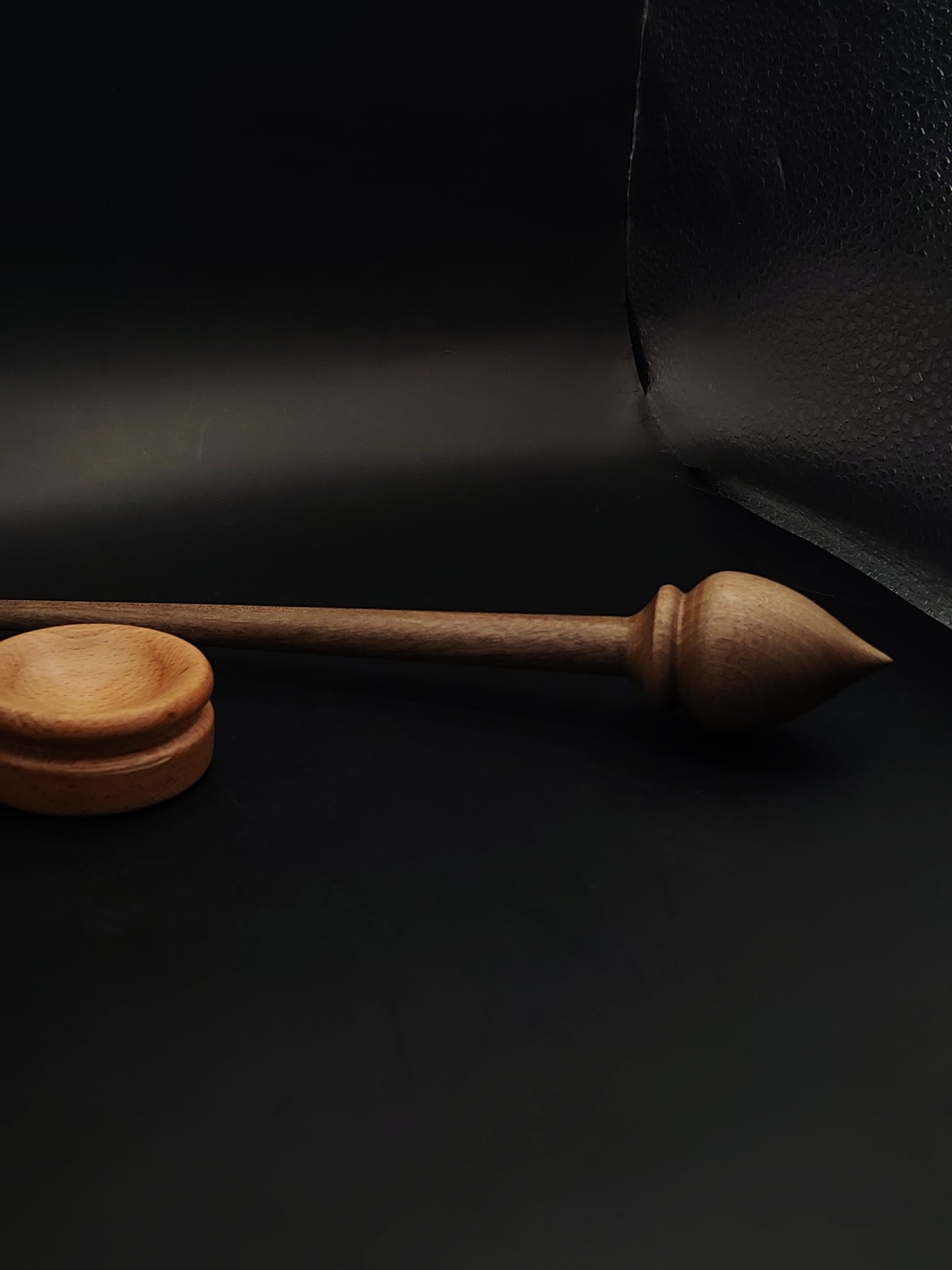 Close-up of spinning setup with walnut spindle and light-toned beech bowl