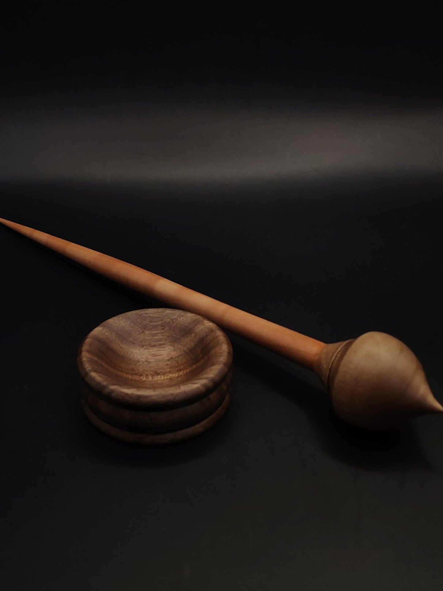 Support spindle set with deep-toned plum shaft and carved walnut whorl for fiber spinning