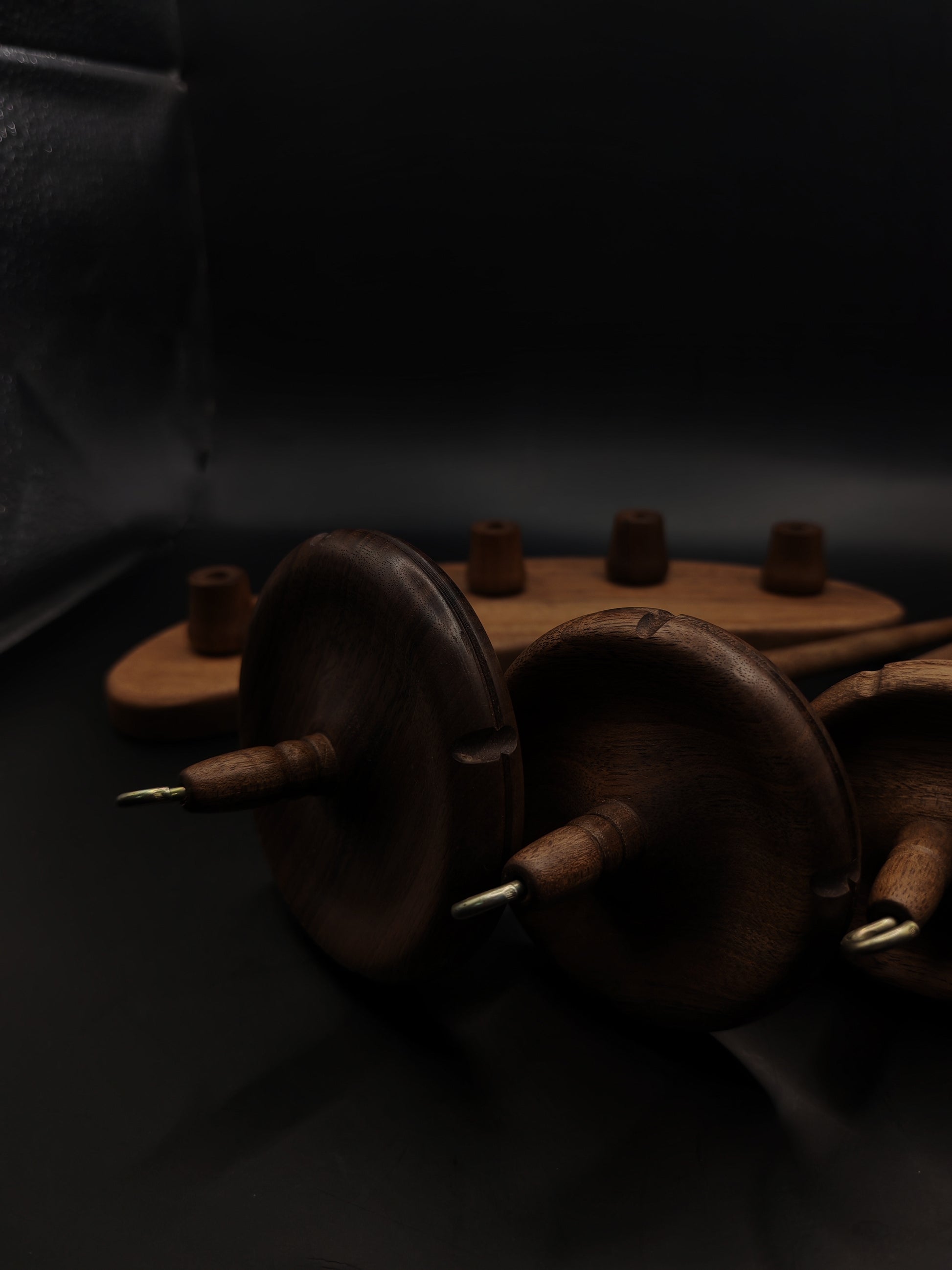 Drop Spindle Set of 5 walnut wood spindles arranged on a dark background, showcasing their craftsmanship and design.