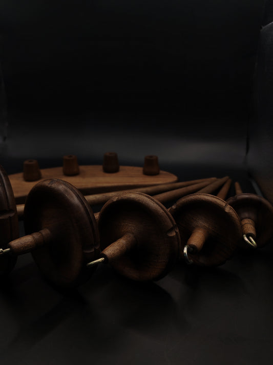 Drop Spindle Set of 5 Walnut Wood complete spinning set displayed against a dark background.